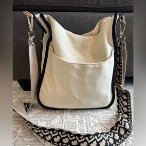Adorned Beautiful cream purse/crossbody with fun black strap.